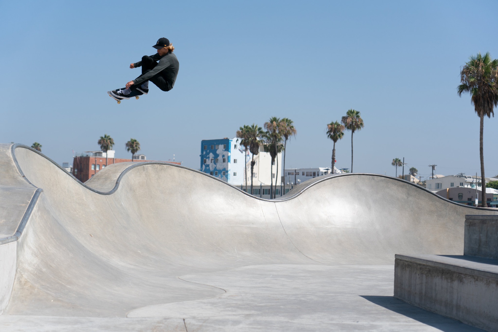 Louie Lopez skating above the Venice Beach bowls